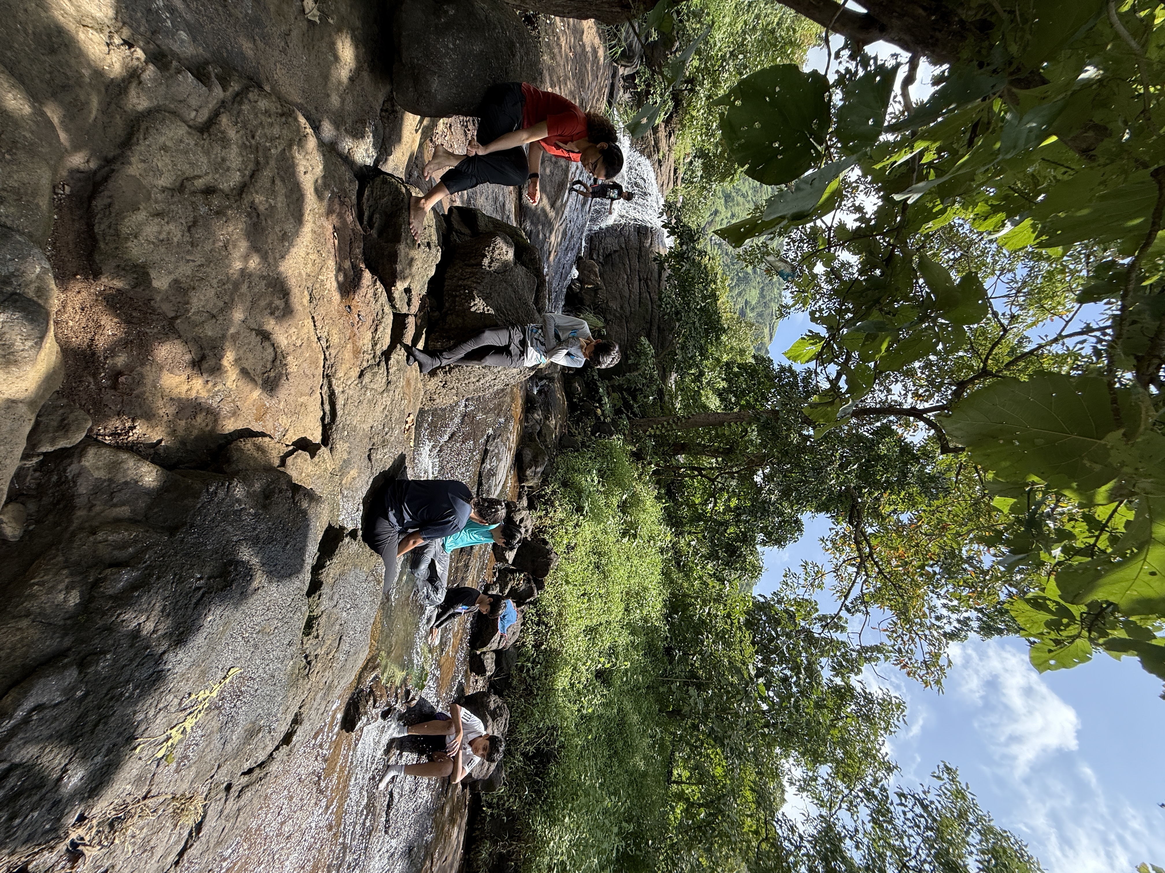 Children relaxing by a waterfall on a nature outing